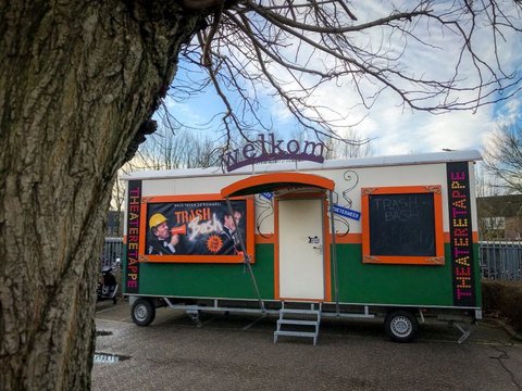 De theaterwagen van De Afvalbutlers onder een boom