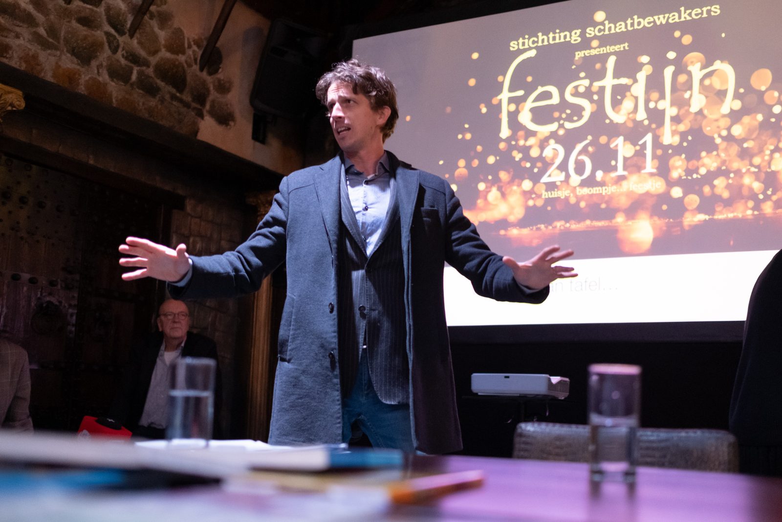 Laurens de Groot spreekt voor een zaal, armen wijd